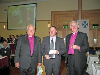 Bobby Cunningham - Webmaster of the Magheragall Parish Church website is pictured after receiving his award from Archbishop Robin Eames (left) and Archbishop John Neill (right) at the Church of Ireland General Synod in the City Hotel, Armagh on Thursday 11th May.