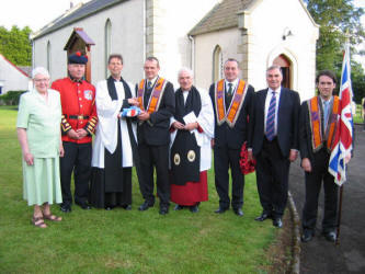 Members of Stoneyford Temperance Lodge present a Union Flag as a gift to Stoneyford Parish Church to mark the 80th Birthday of the Queen. The picture was taken at the Magheragall District Service in Stoneyford Parish Church last Sunday evening. The Rector, the Rev Allister Mallon led the service and the Rev Canon Samuel McComb gave the address. L to R: Mrs Annie McDonald - People�s Warden, Stephen Ellison - Band Chairman, Rev Allister Mallon - Rector, Andrew Richardson - Worshipful Master, Rev Canon Samuel McComb, Mark Harbinson - Deputy Master, Brendan Leckey - Rector�s Warden and Neil Brazil - Treasurer.