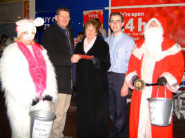 The Rev James Carson, Rector of St Paul�s Parish Church, Lisburn presents a cheque for �492 (the money raised at Wednesday night�s Carol Singing) to Mrs Hazel McCall - Lisburn Organiser for Christian Aid. Looking on is Michael Keegan - Grocery Manager (Tesco), Rosemary Orr (left) and Chris Orr (right). The photo was taken during Carol Singing at Tescos on Thursday 21st December.