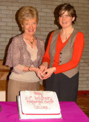 Rector's wives, Maureen Cheevers and Bronwen Dark cut a cake to commemorate the 20th anniversary of Magheragall Parish Senior Citizens' Club last Wednesday afternoon (31st January).