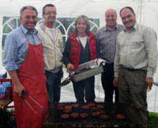 L to R: Paul Graham, Tim Crooks, Linda Graham, Dick Lewis and Norman Wilson pictured in a haze of smoke as they cook the sausages and burgers at the BBQ in Charley Memorial Primary School last Friday night.