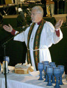 The Right Rev Harold Miller (Bishop of Down & Dromore) conducting Holy Communion for over 4500 young people who packed the King�s Hall for morning worship at Summer Madness.