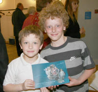 Young curly haired Curtis Dundas (right) whose instantly recognisable photo is featured on the front cover of the book is pictured with his brother Joel as he shows his signed copy of the book. Curtis and Joel are sons of the Rev Paul Dundas, Rector of Christ Church Parish, Lisburn