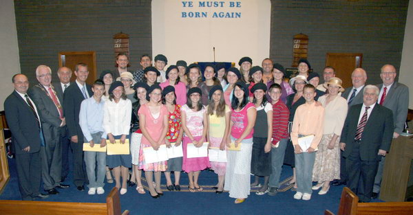 Deborah Girl’s Choir, Romania, pictured at a special evening of gospel praise in Dunmurry Free Presbyterian Church. Included are L to R: (left hand side) Rev Dr Eugen Groza (Romania), Councillor Allan Ewart (Lisburn Mayor), David Williamson MBE (Clerk of Session of Hillsborough Free Presbyterian) and Alderman Edwin Poots MLA (Minister of Environment). L to R: (right hand side)  Rev Dr Stanley Barnes, John Costache (Romania) and Rev Dr Fred Greenfield.