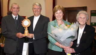 Frank Fox JP and his wife Anna present gifts to the Presbyterian Moderator The Rt Rev Dr Stafford Carson and his wife Patricia at a ‘Launch Weekend’ in Trinity Boardmills Presbyterian Church last Sunday evening. Retired woodworker Frank, a member of the Wood Workers Guild, designed and crafted the ornate wooden body of the clock.