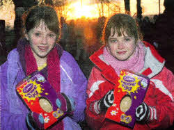 Beth and Zoe Irwin with their Easter eggs against the backdrop of dawn breaking over Castle Gardens
	