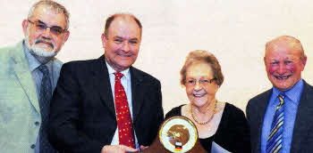 Mr David Gibson (Clerk of Session) presents a clock to retiring organist Mrs lsabel Nicholson in recognition of over 30 years faithful and exceptional service. Looking on are the convenor of the vacancy at Drumlough, the Rev Dr Bert Tosh (left) and senior choir member and former Clerk of Session, Mr Tom Jordan (right).