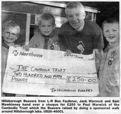 Hillsborough Beavers from L-R Ben Faulkner, Jack Warnock and Sam Mawhinney hand over a cheque for �250 to Paul Warwick of the Cambodia Trust which the Beavers raised by doing a sponsored walk around Hillsborough lake. US26-460CL