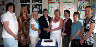 Teachers and staff pictured cutting a cake marking 68 years of the present Tullymacarette Primary School 1939 - 2007. L to R: Isabel McDowell (School Secretary), Helen Eadie (Classroom Assistant), Christina Gibson (Building Supervisor), Mary Hughes (Vice Principal), Laura Cairns (Principal), Lynda Dickson (Part-time Teacher), Carol Jones (Playground and Dining-Room Assistant) and May Gordon (Classroom Assistant).