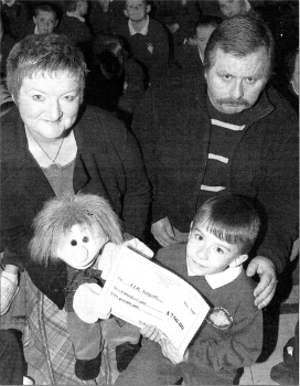 Thomas Doyle and his son Adrian present the two cheques raised by St. Kieran's Primary School in memory of Declan to Fiona Collinson from The Royal Victoria Hospital for Sick Children's Haemotology unit. US2107-524C0