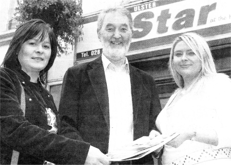 Local man Roy Gamble receives his prize of a short break courtesy of the NI Tourist Board, as well as having his story published later this year. from Alice Murray, Northern Ireland Tourist Board and the Ulster Star's Jenny Monroe (right).