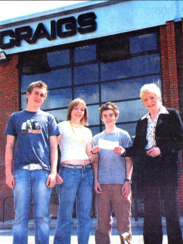 Vi Kirk from Craig's presents Christopher Sisk, Claire McAroe and Mark Craig with a cheque to fund their Polish trek