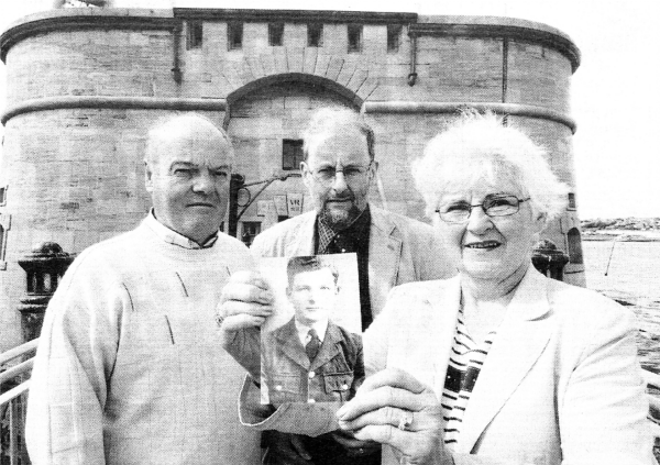 Valerie Irvine, of Hillsborough. displays a photograph of her uncle, Robert `Bertie' Millar, which is featured in Pembroke Dock's Gun Tower Museum. With her are husband Robert (left) and John Evans, of the Pembroke Dock Sunderland Trust. Picture: Martin Cavaney Photography.