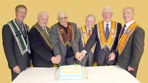 Cutting a cake marking the centenary of Whitehill Orange Hall are L to R: RBP 435 members - Sir Knt Raymond MacRoberts WM, Sir Knt Sam Osborne PM and Sir Knt Jack Coulter PDM and Whitehill LOL 258 members - Br Hugh Thompson DM, Br Bertie MacRoberts PM and Br Will MacRoberts WM.