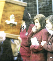 Grief stricken St. Dominic's pupils watch Ciara's coffin being carried from the church.