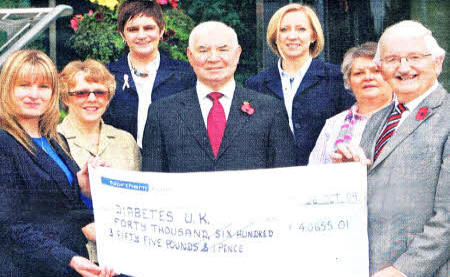 Former Mayor, Councillor Ronnie Crawford presents a cheque for £40,655.01 to Miss Jennifer McGivern of Diabetes UK. Also present at the cheque handover were (14): Mrs Jane Black, Mayor's Office, Lisburn City Council; Mrs Nicola Prentice, Clerical Officer, Lisburn City Council; Alderman Ivan Davis, Lisburn City Council; Mrs Cathy Adamson, Mayor's Secretary, Lisburn City Council and Mrs Jean Crawford.