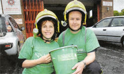 Karen Walker, from NSPCC/Childline, and Jim McGann, from the NI Fire and Rescue Service, taking part in a car-wash at Crumlin Fire Station to help raise funds for the charities. US2009-506cd