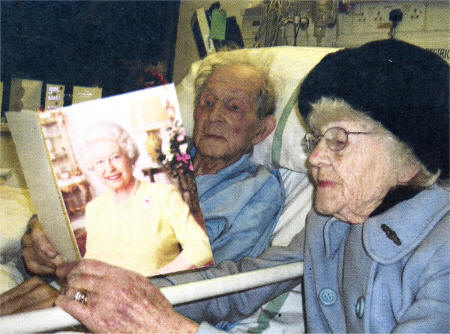 Mabel and her husband Eric look at the card they received from the Queen.