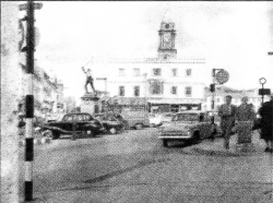 Market Square bathed in afternoon sunshine with cars parked where the sunken gardens are now located.