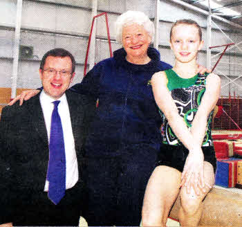 India McPeake on the bar in the Saito Gymnastics Club, Lisburn. With Dame Mary Peters and Barry Funston, EM0 Sales & Marketing Director .Pic by Ian Magill.