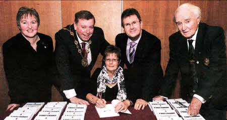 Former UDR Greenfinch Barbara Wilson pictured signing copies of her book 'A Quiet Courage' at the book launch in Lagan Valley Island, Lisburn on Thursday evening November 25. Looking on are L to R: (back row) Amanda Moreno (Curator of the Royal Irish Fusiliers Museum, Armagh), Lisburn Mayor Alderman Paul Porter, Lagan Valley MP Jeffrey Donaldson and Major John Potter.