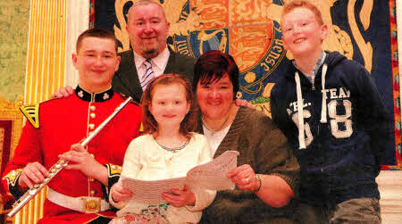 Lisburn teenager Adam Higginson entertains his family: dad Brian, mum Dehra, sister Ellie (7) and brother Jack (10) at the recent event at Hillsborough Castle when the newly formed Corps of Drums of the 1st (Northern Ireland) Battalion Army Cadet Force performed.