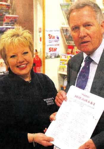 Julie Turkington of McKibbins Service station handing over hospital petitions to Brian Bloomfield- US4111-114A0