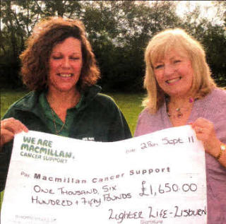 Jackie Adamson hands over a cheque to Joanne Young, Fundraising Manager for Macmillan Cancer Trust NI.