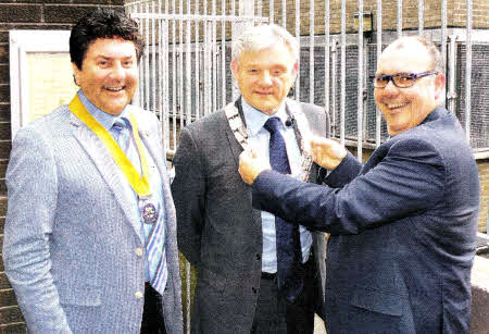 The new president of the Rotary Club of Lisburn, Dale Orr, is presented with the chain of office by outgolng president Trevor Stewart-Included is new vice president Jim Matchett