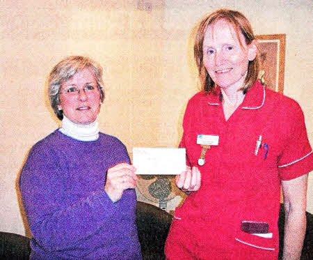 Mimi Gorman of Trio presents Caitlin McCoy with a cheque for £100.