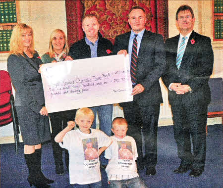 L-R Brenda Hale MLA, Rhoda Walker, lan Walker, Major Ian (Paddy) McCullough Royal Marines, Jeffrey Donaldson MP. Front row L-R Ross Walker, Kyle Walker.