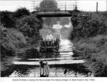Harold McBride crossing the flood under the railway bridge on Blaris Road in the 1950's