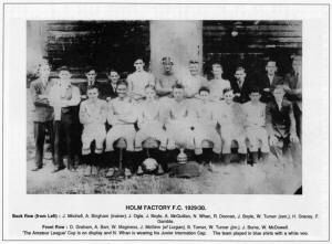 HOLM FACTORY F.C. 1929/30.Back Row (from Left) : J. Mitchell, A. Bingham (trainer), J. Ogle, J. Boyle, A. McQuillan, N. Whan, R. Doonan, J. Boyle, W. Turner (sen.), H. Gracey, F. Gamble. Front Row : D. Graham, A. Barr, W. Maginess, J. McGinn (of Lurgan), S. Turner, W. Turner (jnr.), J. Burns, W. McDowell. 'The Amateur League' Cup is on display and N. Whan is wearing his Junior Internation Cap. The team played in blue shirts with a white vee.