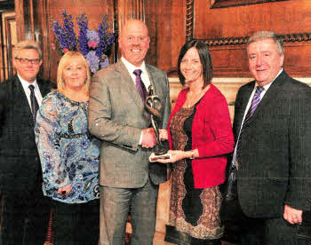 Jason Harries, Managing Director of CHKS presents the award to, from left to right, Jeff Pears, Karen Mcllveen, Diane Keown and Alan McDowell from South Eastern HSC Trust.