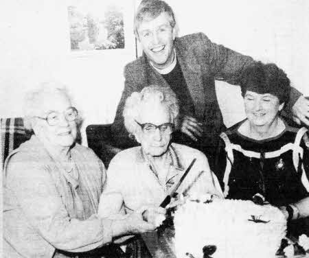 Mrs. Armstrong cuts her cake to celebrate her 102 birthday watched by her daughter, Mrs. Jane Clements, Mrs. Esme Lilburn, Lisburn's Mayoress and the Rev Stuart Lloyd, Rector of All Saints Eglantine