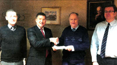 Will Murdoch is presented with a retirement gift by Rowan Black after serving 34 and a half years at Greens Foodfare.