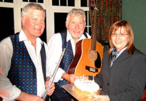 Gerty McCaugherty - Manager of the Ivanhoe Hotel is pictured presenting Drew Rowan (left) and Noel McMaster of Bakerloo Junction with a �Welcome Back� cake on Friday 1st September.